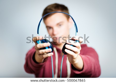 successful man gives listening to music with headphones isolated on a gray background