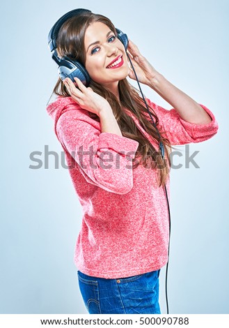 Young woman listening music in headphones. Studio portrait of smiling girl.