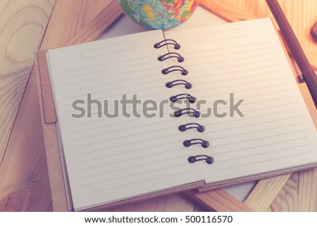 blank notebook with pen and calculator on wooden table, business concept with retro effect.