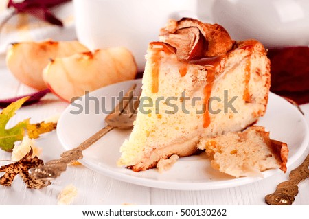 A single slice of apple pie and leaves on white background