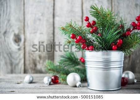 Christmas composition with spruce, red berries and white, silver, red xmas ornaments on rustic wood background. Merry christmas card. Winter holiday theme. Happy New Year.