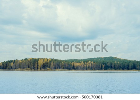Autumn landscape - autumn mountain with woods, pond and sky