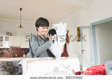 Half length of couple of young handsome caucasian man and woman unpacking christmas tree, looking downward, concentrate - christmas, holiday, winter concept
