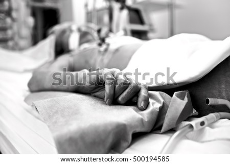 Hand of extremely exhausted patients dying in a hospital bed. Black and white conceptual photography.  Royalty-Free Stock Photo #500194585