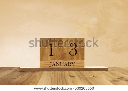 Cube shape calendar for January 13 on wooden surface with empty space for text.