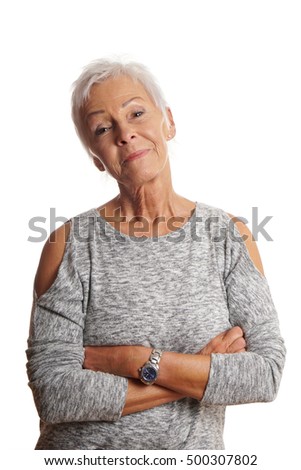 confident mature woman with arms folded and head tilted. isolated on white.