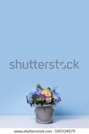 Colorful beautiful bouquet of pink, yellow, red and blue flowers in the box. Empty space for your advertising text. Flowers 
background
