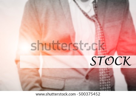 Hand writing STOCK with the young business man on background. Business concept. Stock Photo.