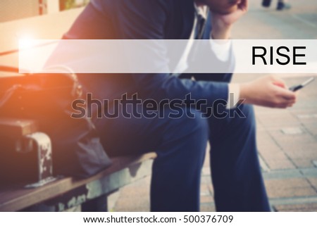 Hand writing RISE with the young business man on background. Business concept. Stock Photo.