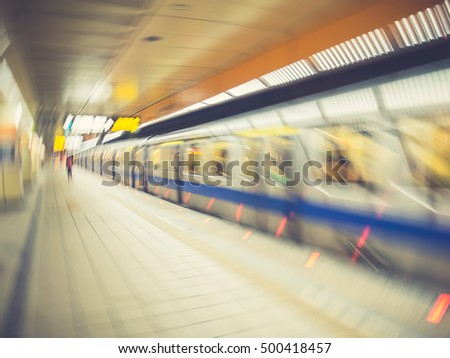 One person walking on subway platform. Train moving. Rotating effect. Motion blur. Toned image. City life background.