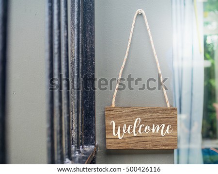 Welcome, wooden sign in front of room