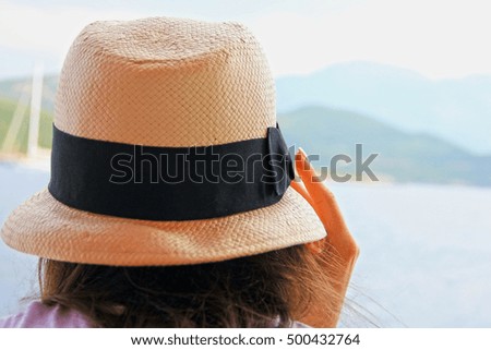 girl in the hat rear view, looking at the sea and the beach