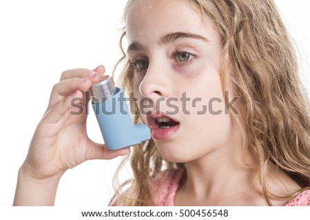 A child using inhaler for asthma. White background studio picture.