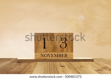 Cube shape calendar for November 13 on wooden surface with empty space for text.