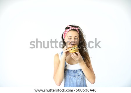 beautiful hipster girl is holding a burger and going to eat it. Model on a white background