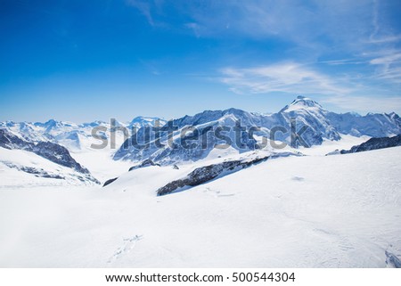 Aerial view of the Alps mountains in Switzerland. View from helicopter in Swiss Alps. Mountain tops in snow. Breathtaking view of Jungfraujoch and the UNESCO World Heritage - the Aletsch Glacier