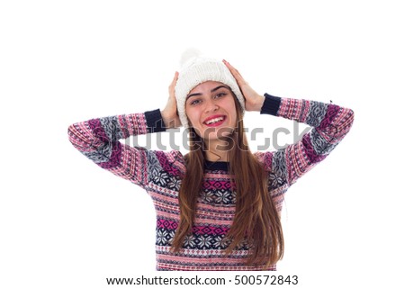 Woman in sweater touching her white hat