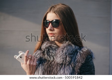 carven girl in a wreath on the street with a phone