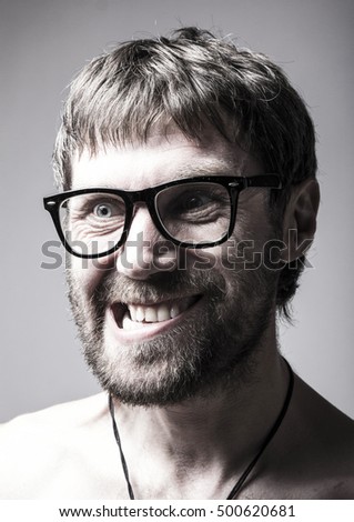 bearded man in glasses plays the fool. crazy man, funny expression