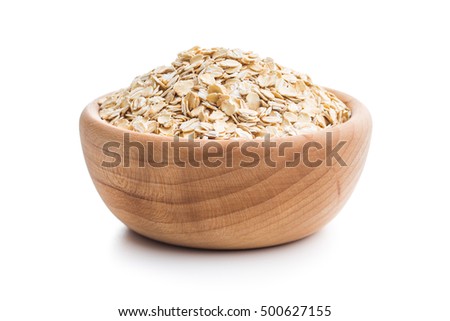 Dry rolled oatmeal in wooden bowl isolated on white background. Royalty-Free Stock Photo #500627155