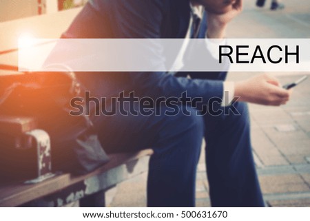 Hand writing REACH with the young business man on background. Business concept. Stock Photo.