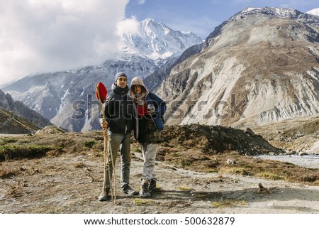 A couple of happy europeans posing for the photo on the trail in the mountains. Tilicho lake base camp, Annapurna Conservation Area, Himalayas, Nepal. 

