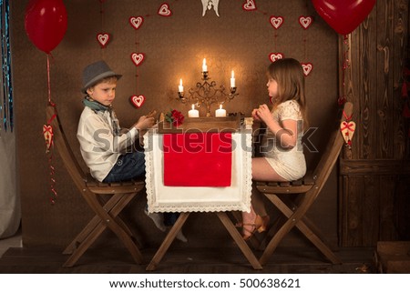 a boy and a girl at table in the cafe, concept valentines day, dark background, candle