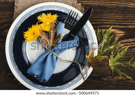 Rustic autumn place setting with  yellow flowers on rustic wooden table, top view, Thanksgiving decorations with copy space