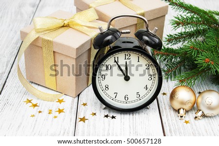 christmas clock on a  wooden background with fir tree and gift boxes