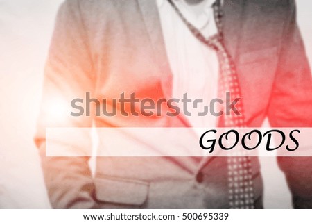 Hand writing GOODS with the young business man on background. Business concept. Stock Photo.