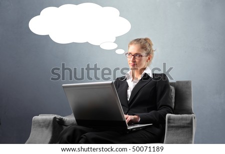 Businesswoman sitting on an armchair with a laptop and thinking
