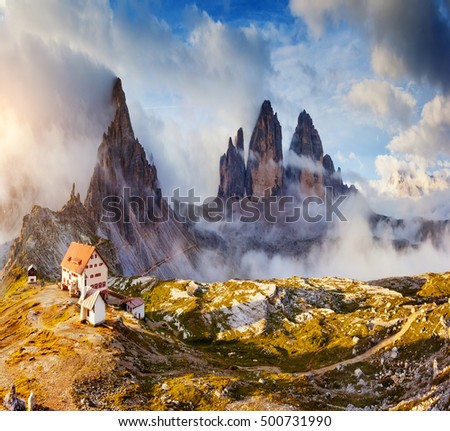 Great sunny view of the National Park Tre Cime di Lavaredo with rifugio Locatelli. Dolomites, South Tyrol. Location place Auronzo, Italy, Europe. Tourist attraction. Dramatic cloudy sky. Beauty world.