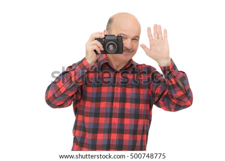 elderly man looks into the camera viewfinder in search of the miraculous image and waving his hand