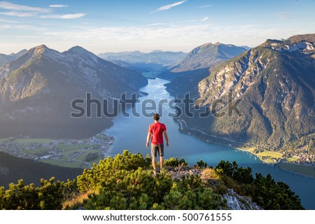 Mountaineer enjoying the view over lake Achensee in summer, Austria Tyrol Royalty-Free Stock Photo #500761555