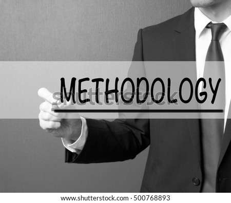 Methodology. Businessman in a suit with a marker writing on visual screen