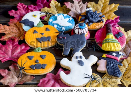 Top view of sweet halloween cookies on autumnal leaves 