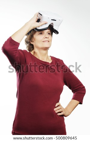 Senior woman with virtual reality headset is advertising VR. Old woman smiled wearing in vr glasses on a white background. New technologies and old aged woman.