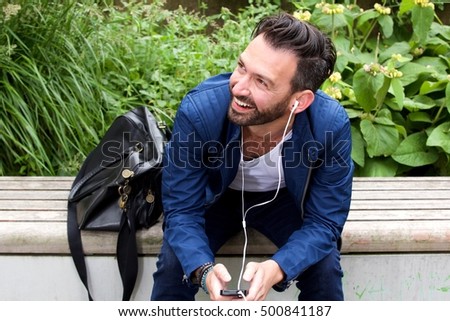 Portrait of relaxed man sitting outdoors and listening to music  