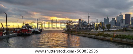 Toronto Docks Port Tugs Golden Dusk Sunset Banner. Late afternoon, early evening sunset shot of downtown Toronto from them eastern ports area with docked tugboats.