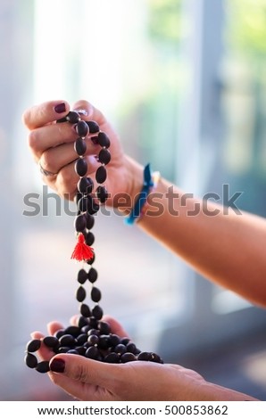 Woman hand holding mala beads for meditation. Blurred background. Concept for concentration.