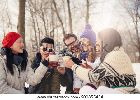 Group of friends enjoying in the snow in winter