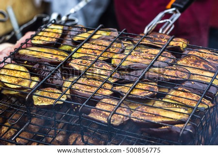 Fresh healthy eggplant or aubergine preparing on a barbecue grill over charcoal. Grilled aubergines eggplants slices. Vegetarian, Mediterranean cuisine. Delicious Food, vegetables on bbq party. 