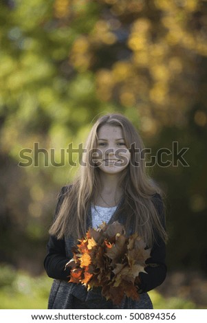 Girl with a cute smile on sunny autumn day