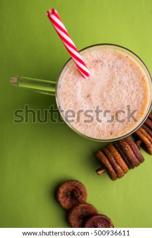 Anjeer or Fig milk shake in a glass jar with whole dried fruits over colourful or wooden background. selective focus