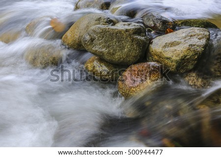 Slow motion river stream flowing among stones at Sungai Sedim Kulim, Kedah, Malaysia.
