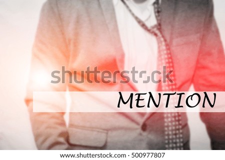 Hand writing MENTION with the young business man on background. Business concept. Stock Photo.