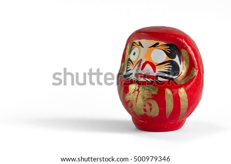 Big red Daruma doll, with the typical missing eye, facing to the left, standing on the right of the picture, on a white background.