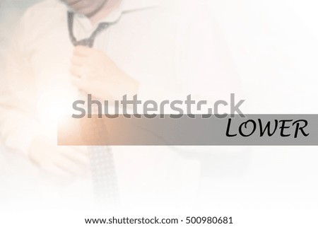 Hand writing LOWER with the young business man on background. Business concept. Stock Photo.