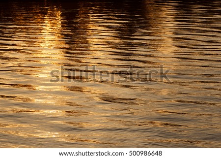 Abstract sunset reflection on river and has strip or small wave on water