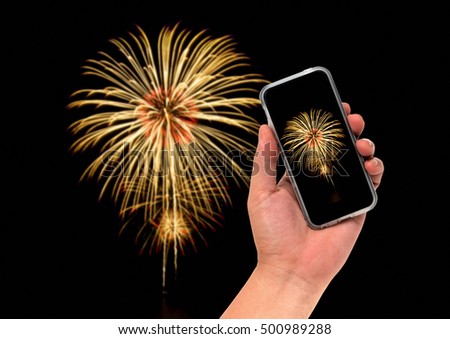 hand holding cell phone for take picture concept on blurred Fireworks background